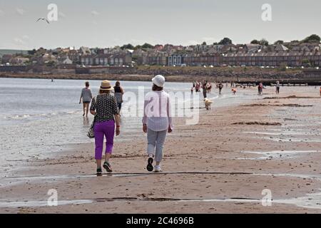 Portobello, Edinburgh, Scotland, UK. 24 June 2020. The hot weather brought families out but the seaside was not overly busy, plenty room to keep a social distance on the beach and promenade. People out on various paddle boards and inflatables and others having picnics on the sandy beach. Stock Photo