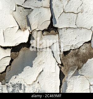 Old plaster wall surface. Abstract textured background. Deep cracks on a white wall. Closeup Stock Photo