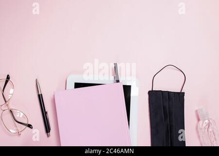 Flat lay composition with medical mask, table, notepad and coffee on pink background. Stock Photo