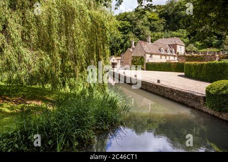 An old mill beside the  River Coln on the edge of the Cotswold village of Coln Rogers in the Coln Valley, Gloucestershire UK Stock Photo