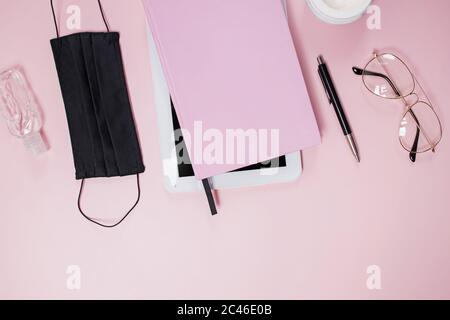 Flat lay composition with medical mask, table, notepad and coffee on pink background. Stock Photo