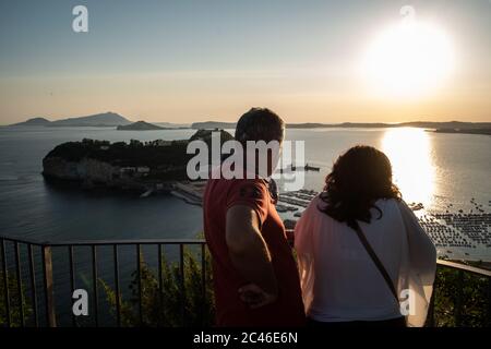 Naples, Italy. 23rd June, 2020. NAPLES, ITALY - JUNE 23 - A couple watch the sunset from the viewpoint of the Virgilian Park of Posillipo in Naples, June 23, 2020. Credit: Manuel Dorati/ZUMA Wire/Alamy Live News Stock Photo