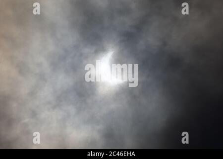 The annular solar eclipse observed as a rare solstice partial solar eclipse with clouds covered sky in monsoon from Kolkata. The first solar eclipse i Stock Photo