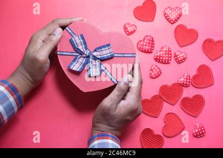 Man holding small red present box in hands with Heart. Stock Photo