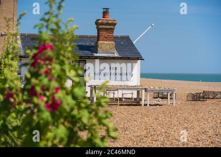 View of the South Lookout with Hollyhocks in the foreground located on the beach in Aldeburgh, Suffolk. UK Stock Photo