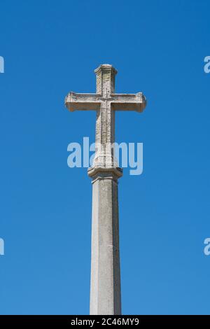 Stone cross / crucifix on Aldeburgh War memorial against a plain blue sky, Aldeburgh, Suffolk. UK. Stock Photo