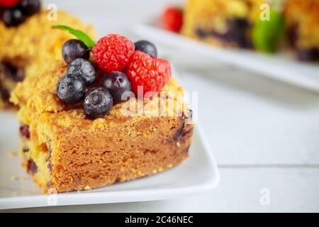 Homemade berry coffee cake with fresh berries on white plate and white background. Close up. Stock Photo
