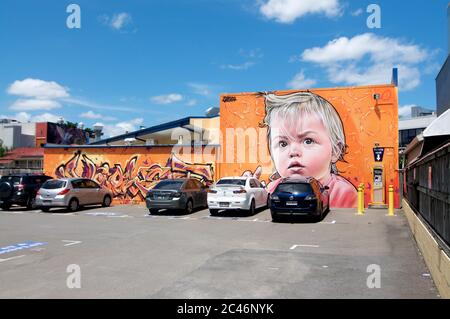 Brisbane, Queensland, Australia - 29th January 2020 : A beautiful mural Art painting on the wall illustrating a little baby on a parking lot in West E