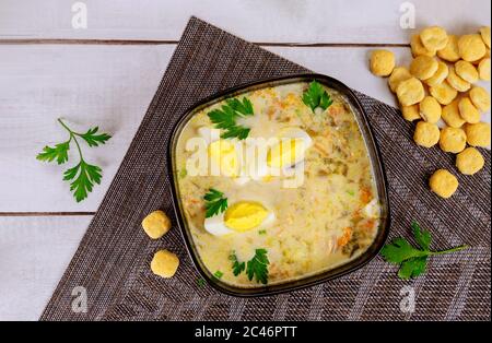 Creamy vegetable soup in black bowl with egg and crackers. Thai cuisine. Stock Photo