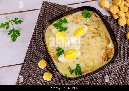 Creamy vegetable soup in black bowl with egg and crackers. Japan cuisine. Stock Photo