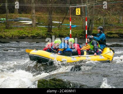 People in rubber raft going down rapids with canoe slalom posts, Grandtully, Tay River, Perthshire, Scotland, UK Stock Photo