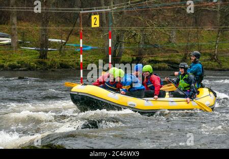 People in rubber raft going down rapids with canoe slalom posts, Grandtully, Tay River, Perthshire, Scotland, UK Stock Photo