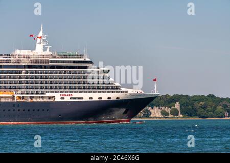 Southampton, UK. Wednesday 24 June 2020. Cunard's MS Queen Victoria leaves the port in Southampton to be moored in Poole Bay near Bournemouth. Netley Castle in the background. Credit: Thomas Faull/Alamy Live News Stock Photo