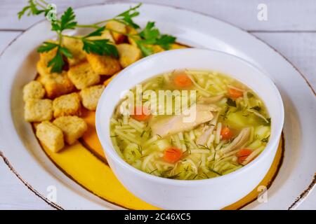 Noodle soup with chicken, parsley, vegetable and croutons. Stock Photo