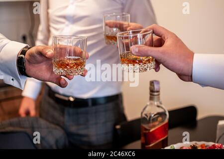 Mans clink glasses with whisky Stock Photo