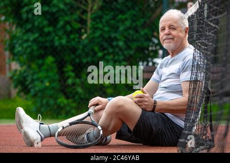 Portrait of senior man playing tennis in outside, retired sports, sport concept Stock Photo