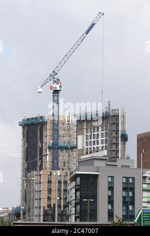 A crane dwarfs skyscraper buildings under construction near Birmingham City Centre. Stock Photo