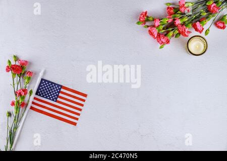 US flag, flowers and candle on white background. Memory or Veterans Day. Stock Photo