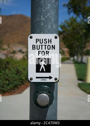 Crosswalk button and sign on street pole. Stock Photo