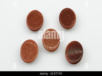 Natural oval cabochon brown aventurine gold on the white background Stock Photo