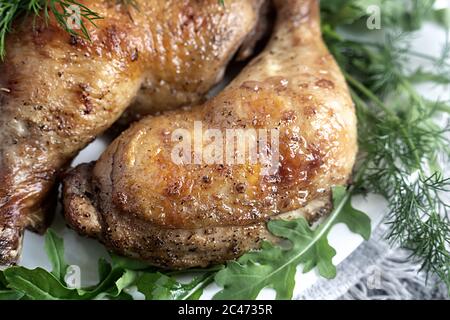 Baked chicken drumstick on a plate with herbs. Stock Photo