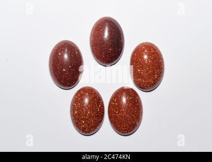 Natural oval cabochon brown aventurine gold on the white background Stock Photo