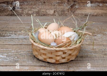 Basket with homemade chicken eggs on a wooden background. Stock Photo
