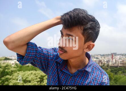 Young man suffering from strong headache or migrant.sky background. Stock Photo