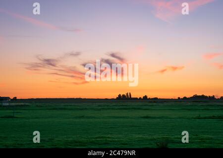 Beautiful pink colored cirrus clouds over the dutch countryside during the period of the longest days Stock Photo