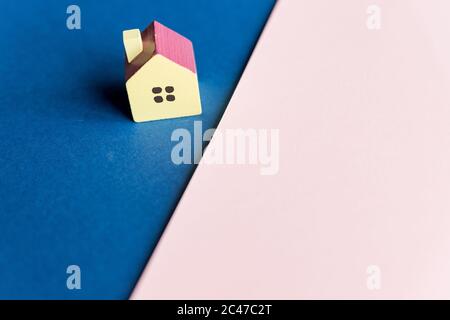Real estate, house model outdoors, closeup.Wooden model house on a Geometric pink and blue background with copy space.Concept for property ladder Stock Photo