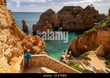 Lagos, Portugal - 6 March 2020: Tourist looking at the cliffs at Ponta da Piedade Stock Photo