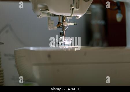 Dark sewing machine brother with white thread coming down Stock Photo
