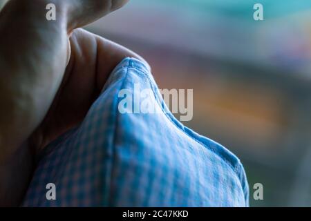 Deluxe blue gingham fabric mask front nose piece close-up blown out background Stock Photo