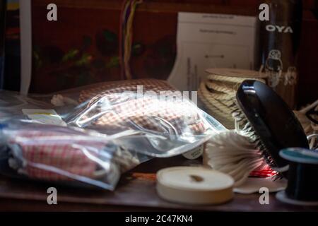 Dark deluxe face masks in plastic surrounded by sewing utensils tape rope cord mask template Stock Photo