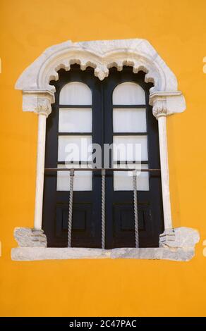 Beautiful Arabesque - Gothic Manueline marble window and surround on a yellow facade. Beja, Alentejo region, Portugal. Stock Photo