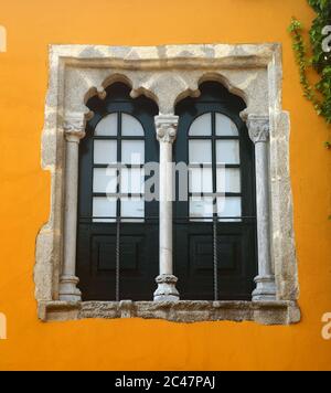 Beautiful Arabesque - Gothic Manueline marble window and surround on a yellow facade. Beja, Alentejo region, Portugal. Stock Photo