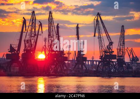 Sea port and industrial cranes, Varna, Bulgaria.Sunset over the Varna lake Stock Photo
