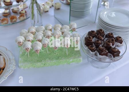 High angle shot of chocolate cookies and candies with sheep figures on the table - party concept Stock Photo