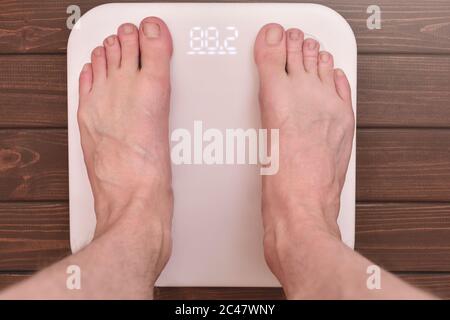 men's feet on an modern electronic scales. sports concept Stock Photo