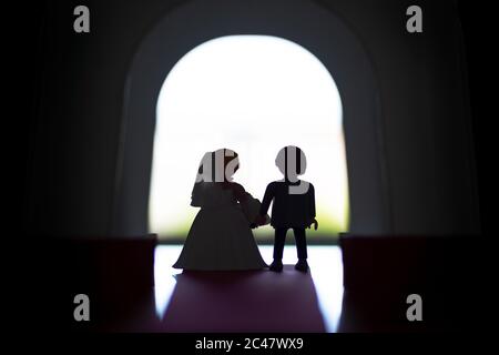 Silhouette of a bride and groom walking out of church Stock Photo