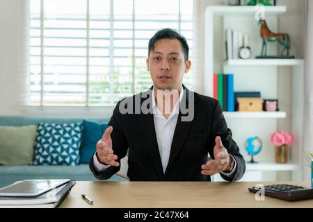 Mixes race Businessman talk with his client by video call communication remote location use modern meeting online in living room at home for social di Stock Photo