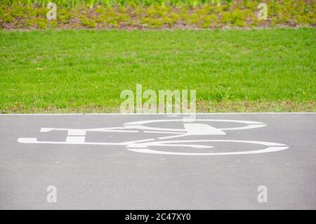 Bicycle route with a symbol in front of green grass. Stock Photo