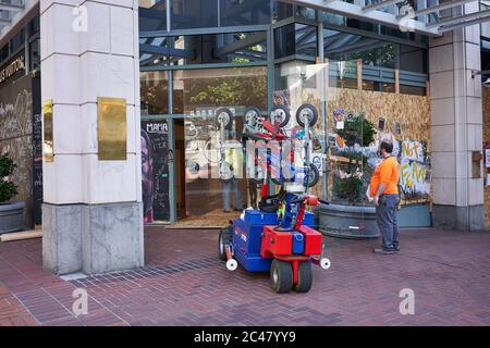Workers replace the broken glass in Pioneer Place in downtown Portland as the shopping mall reopens on Tuesday amid the ongoing protest and pandemic. Stock Photo