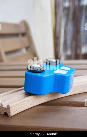Vertical selective focus shot of a toy blue car on a wooden table Stock Photo