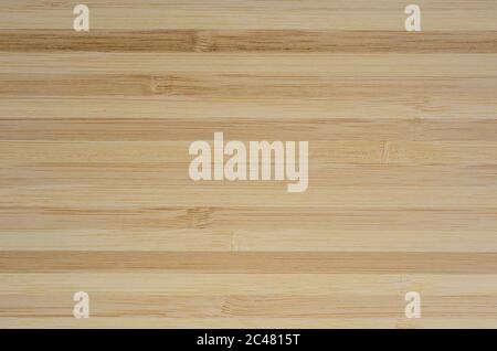 Texture of the surface assembled from bamboo planks. Background of a wooden cutting Board. Stock Photo