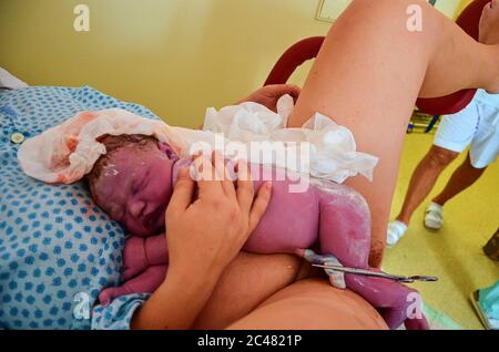New born baby with umbilical cord after successful childbirth. Real birthing and new born baby in a hospital Stock Photo