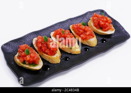 classic tomato bruschetta, fresh tomato cubes marinated in olive oil and basil with bread crouton Stock Photo