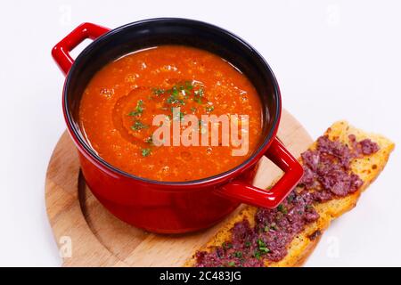 tomato soup served in a hot metal bowl with crunch bread stick Stock Photo