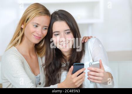 two roommates using their smart phones on line at home Stock Photo