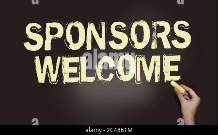 Sponsors welcome phrase handwritten on chalkboard with chalk in a hand. Business startup concept Stock Photo